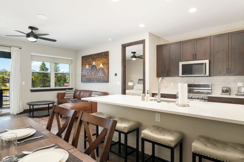 Open concept layout with fully stocked kitchen, dining table, and living area