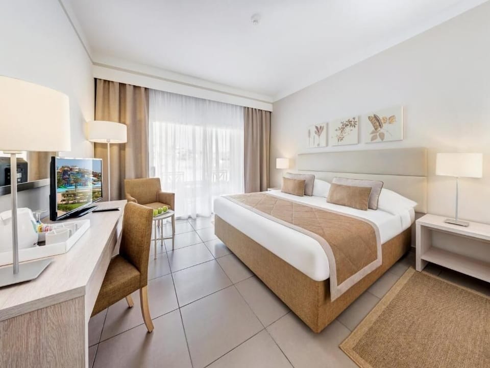 Stretch out in a bright bedroom with desk and TV.