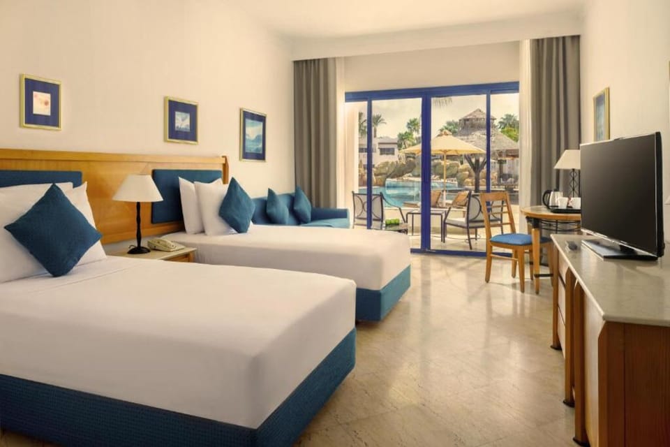 Unwind in twin beds with a sparkling poolside terrace view.