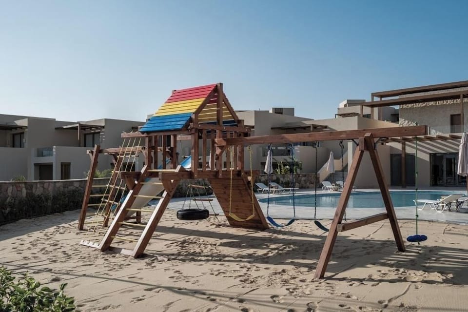 Watch kids giggle on the playground beside sparkling pools.