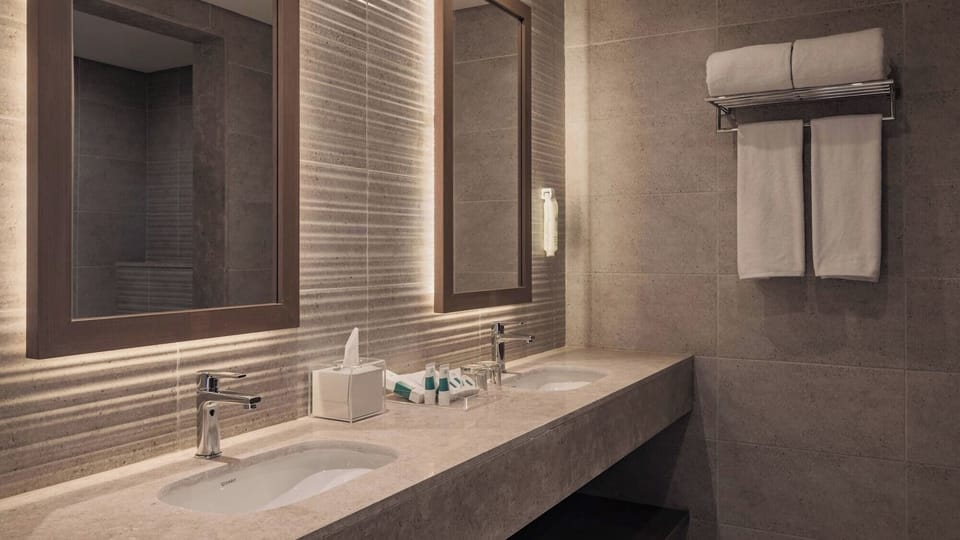 Refresh in a sleek stone bathroom with double vanity space.