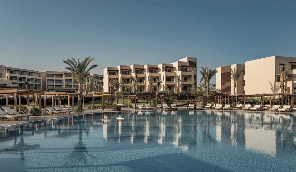 Unwind on plush loungers circling the calm, mirror-like pool.