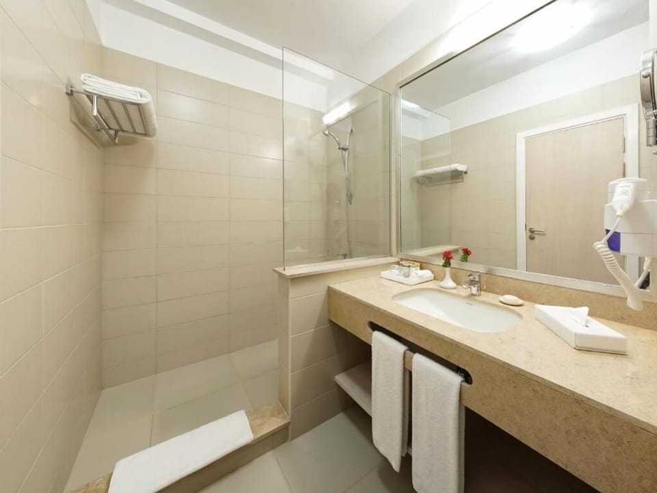 Refresh in a spotless bathroom with glass shower and plush towels.