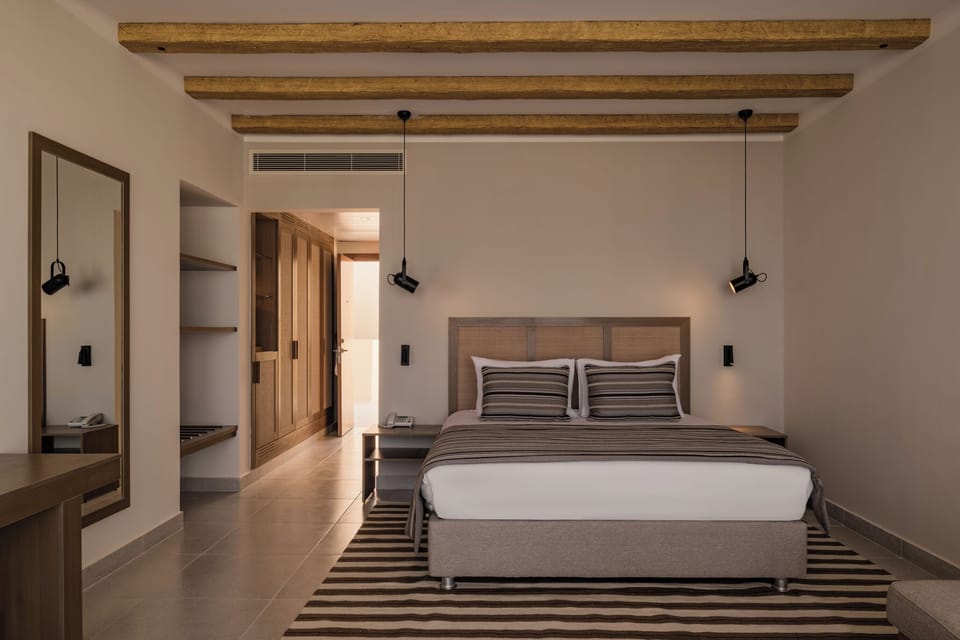 Unwind in a serene king bed under warm wood beams.