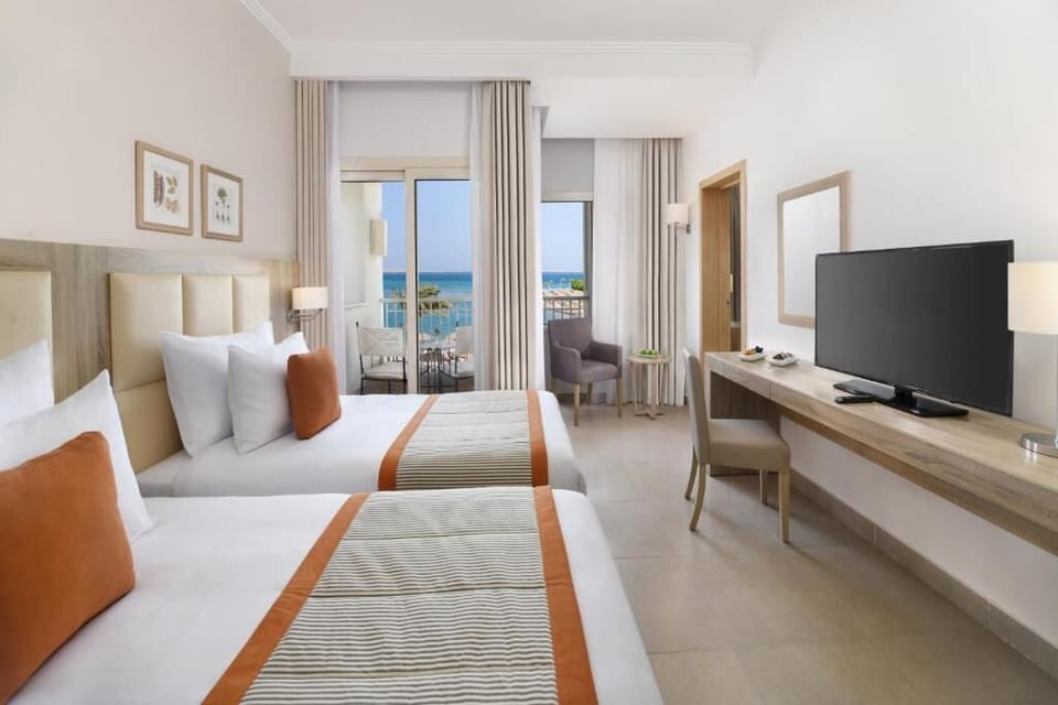 Share the sunrise—twin beds with calming balcony ocean views.