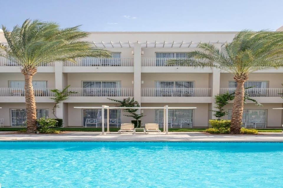 Lounge poolside with wide blue water and serene scenery.