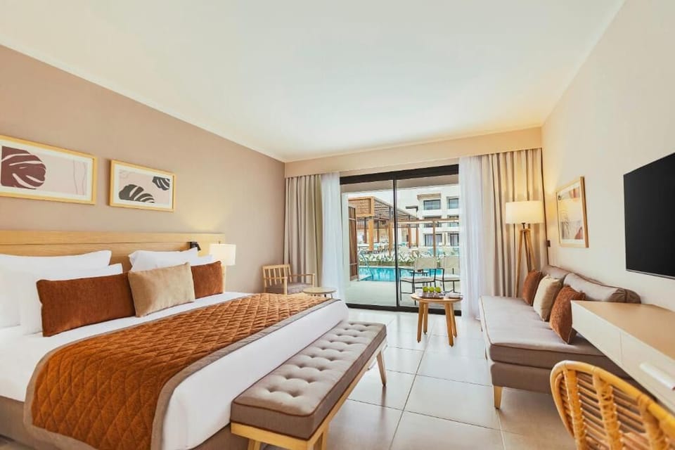 Lounge in a bright suite with pool views beyond glass.