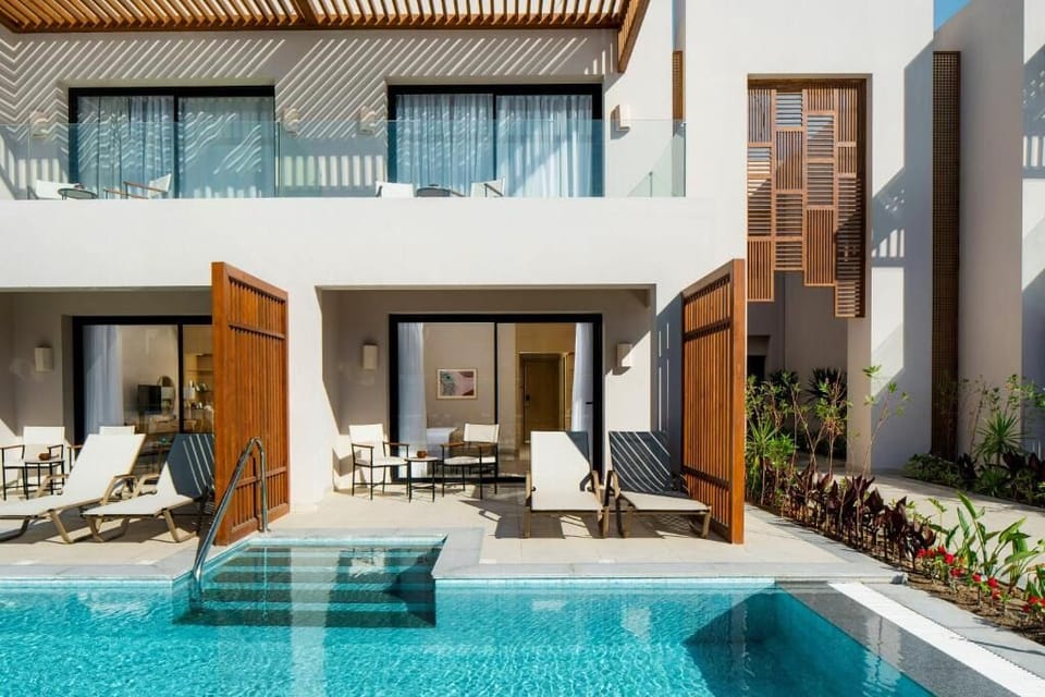 Soak up sunshine on chic loungers beside the resort pool.