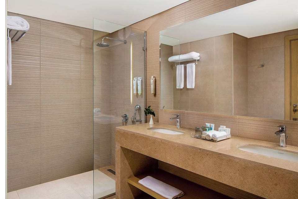 Refresh under a rainfall shower in a sleek spa bathroom.