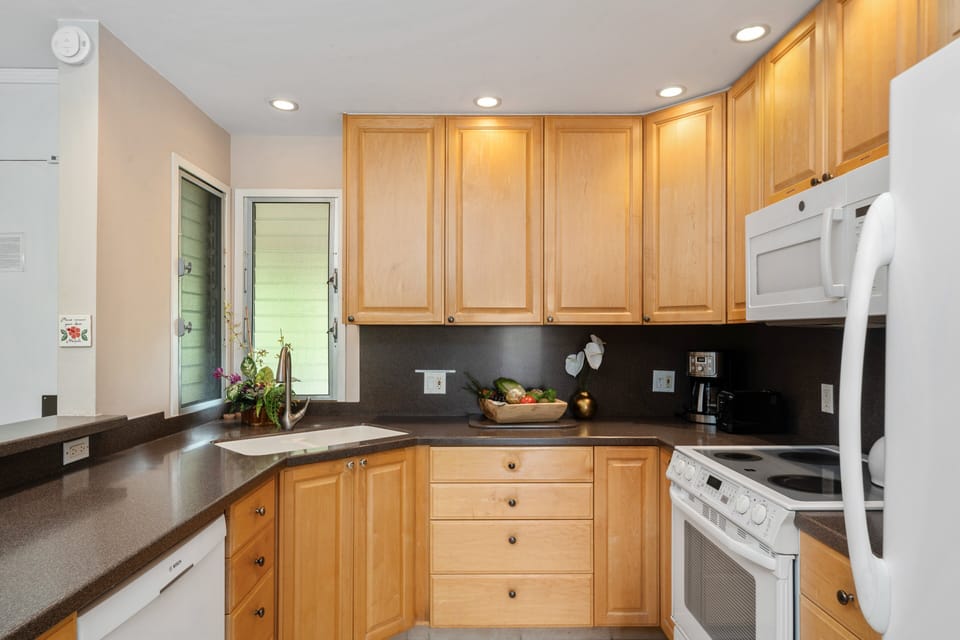 Wooden cabinets and drawers with white appliance featured in the kitchen