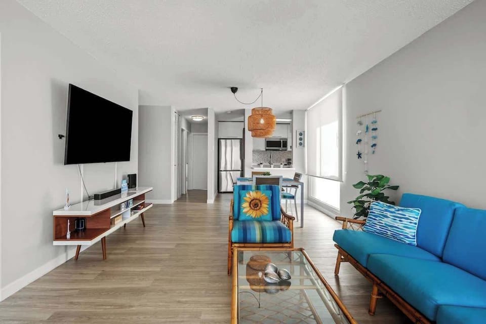 Spacious and inviting! This vibrant living room offers comfortable seating, a large flat-screen TV, and ample natural light, creating the perfect hub for relaxation and entertainment.