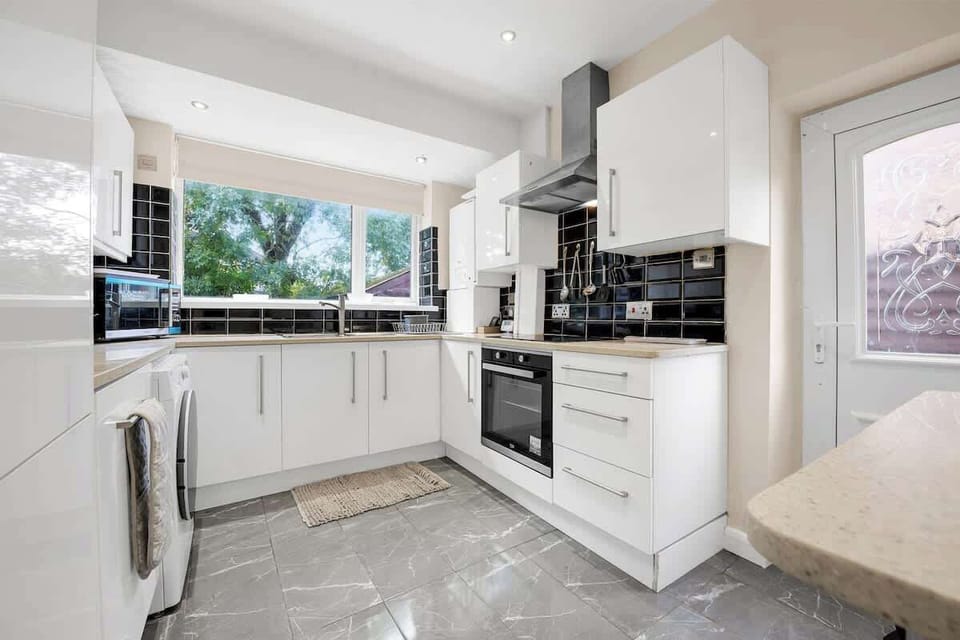 Modern fitted kitchen with built-in oven, hob, and plenty of worktop space for preparing meals during your stay