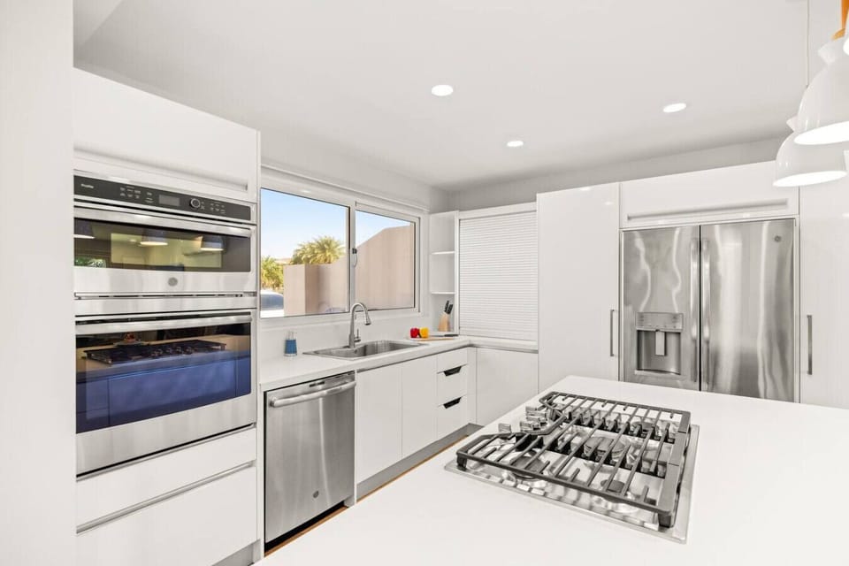 Gas cooktop, oven, microwave, dishwasher, and stainless steel fridge.