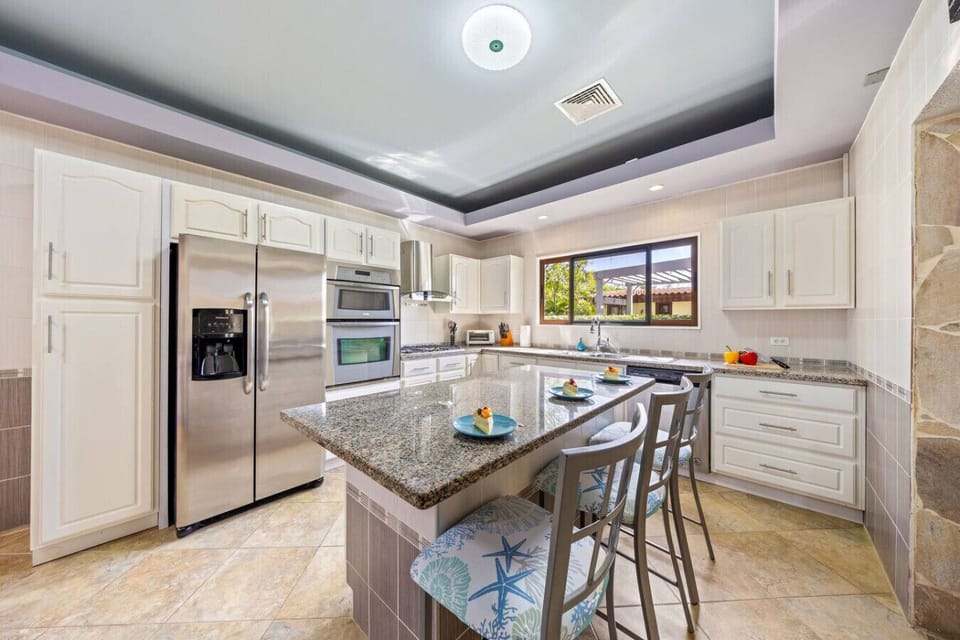 Fully equipped kitchen with island seating and modern appliances.