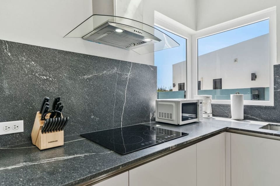 Clean modern design with black stone backsplash.