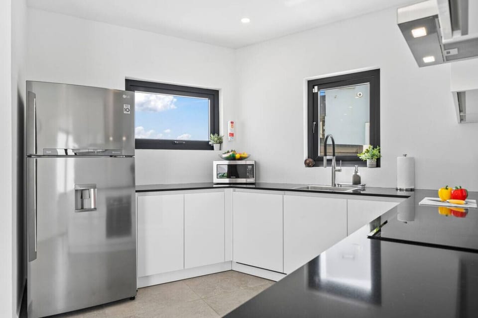 Open kitchen with island bar, ideal for casual dining & chats.