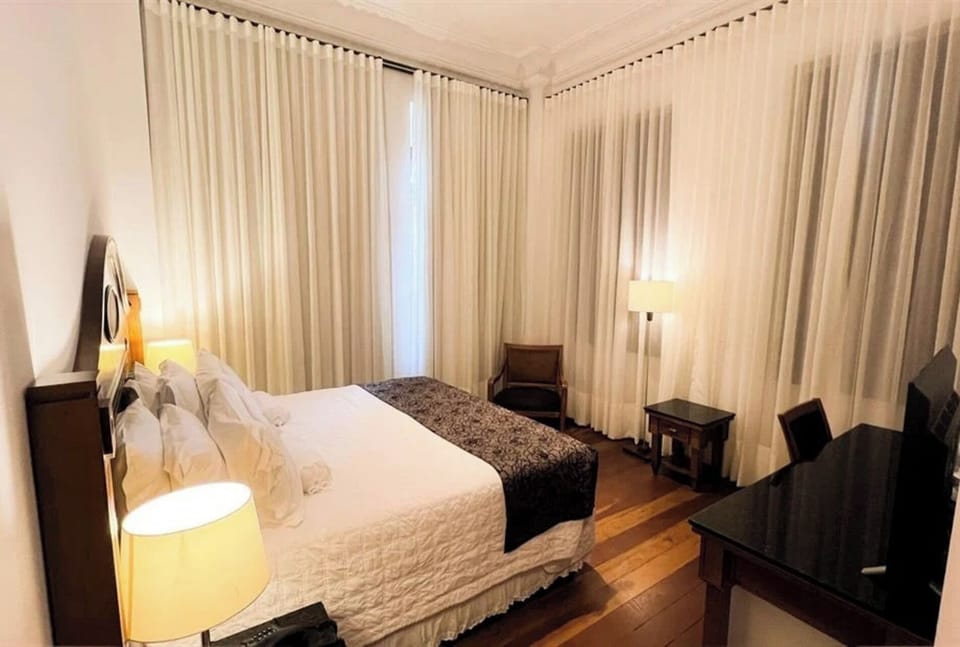 Unwind quietly with soft curtains and a cozy reading chair.