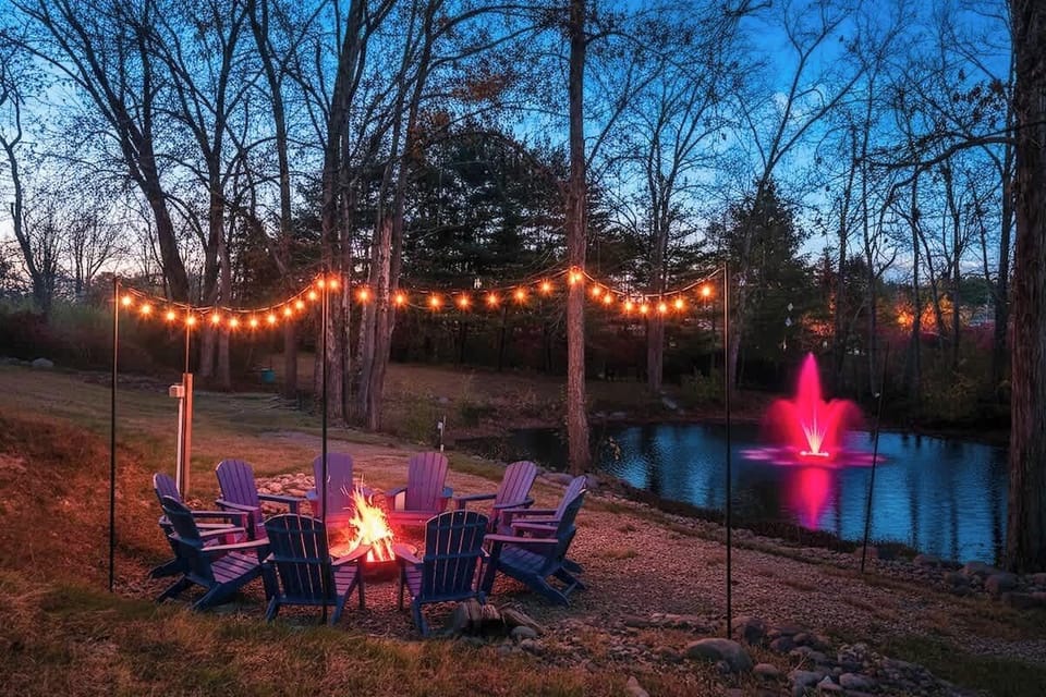 Magical backyard firepit scene w/ string lights & forest views for memorable nights outside.