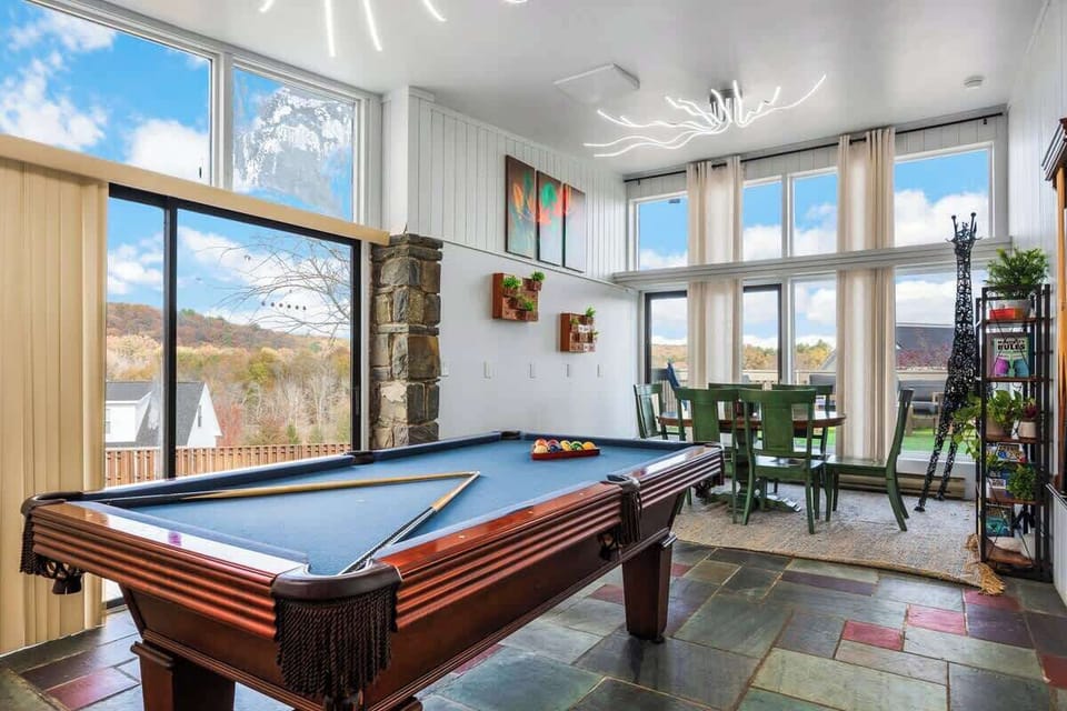 Game room fun w/ pool table, TV, & big windows bringing in natural light while you play.
