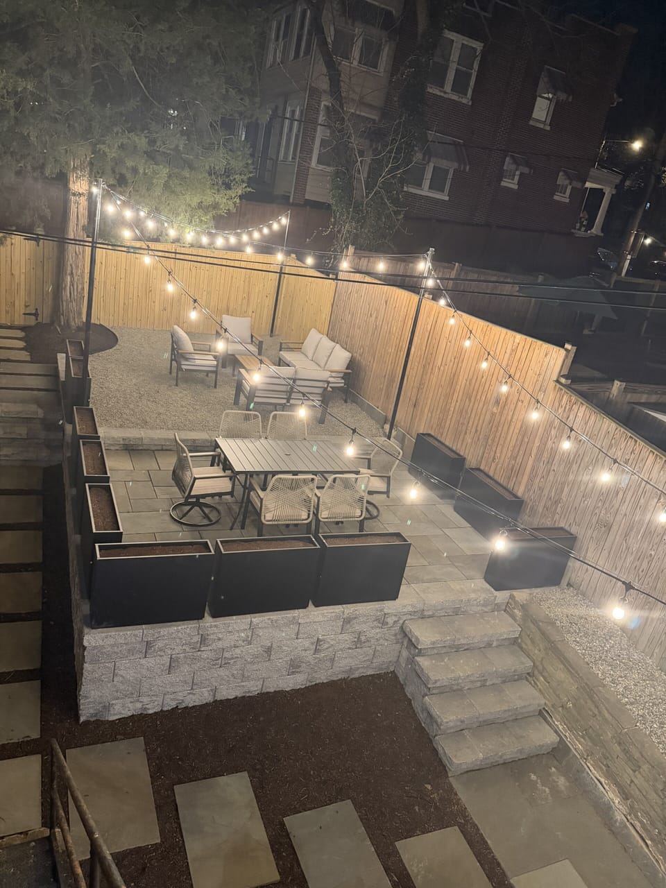 Cozy string-lit patio with dining and lounge seating for perfect nights.