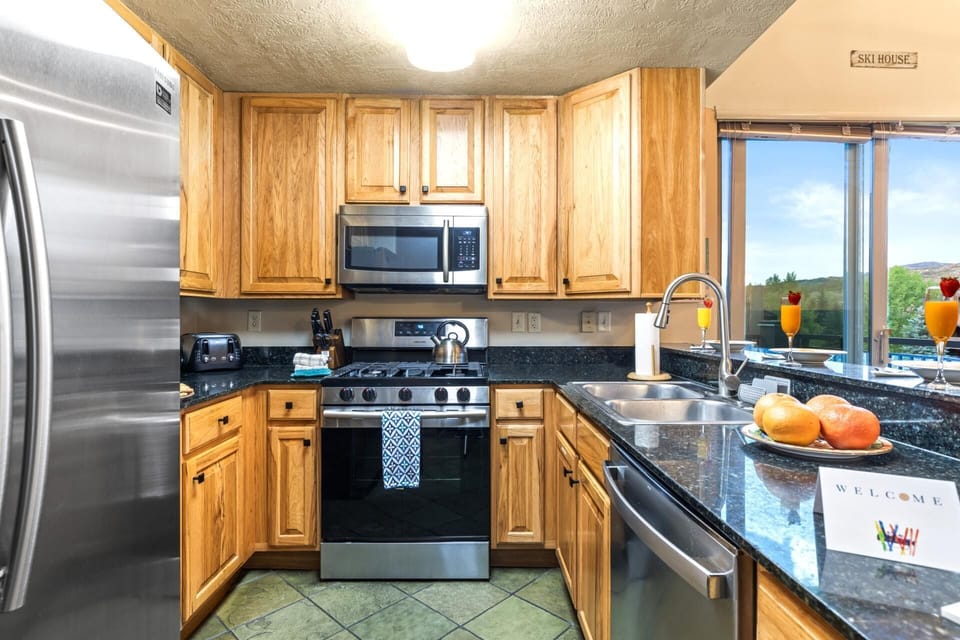 Fully equipped kitchen with granite counters, gas range, and stainless appliances makes dining in effortless.