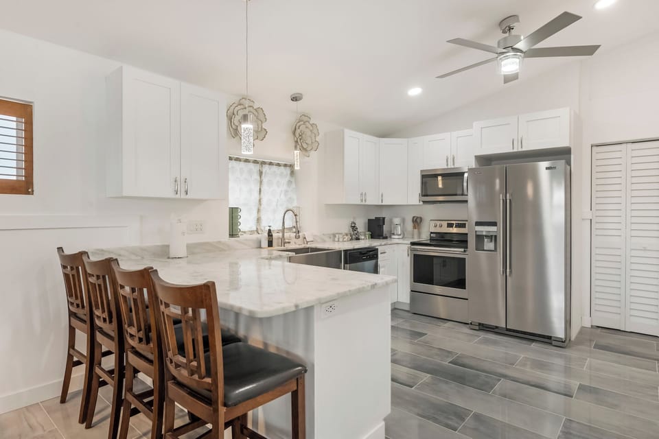 Bright kitchen with island seating and stainless appliances.