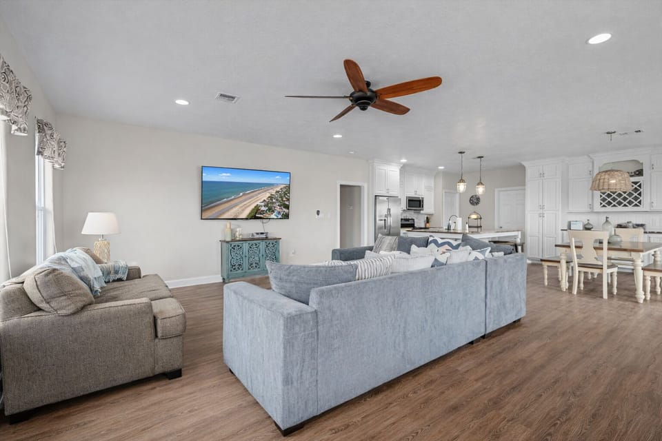 Bright coastal living room with modern furnishings, high ceilings, and open floor plan perfect for group gatherings.