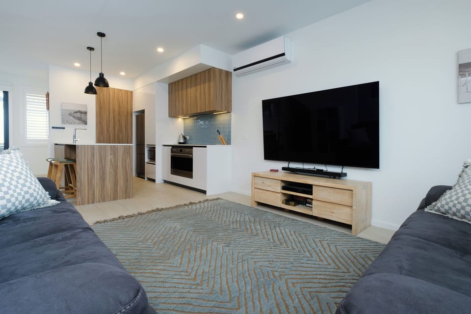 Living room with large smart flat screen and two double recliners.