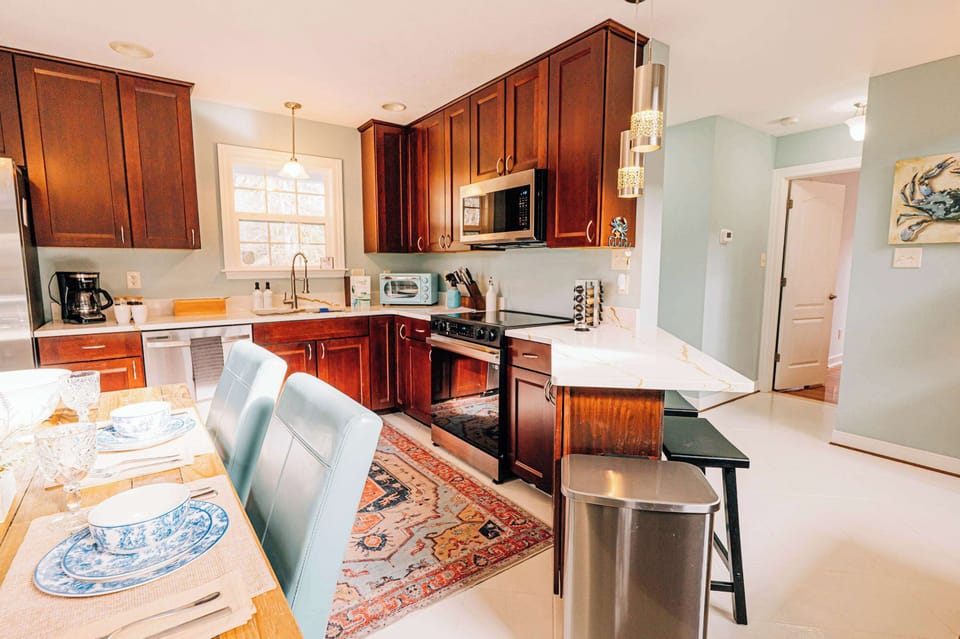 Bright & beautifully styled kitchen with clean lines, modern finishes, and plenty of prep space—ideal for casual cooking, morning coffee, or gathering with friends before heading out for river fun.
