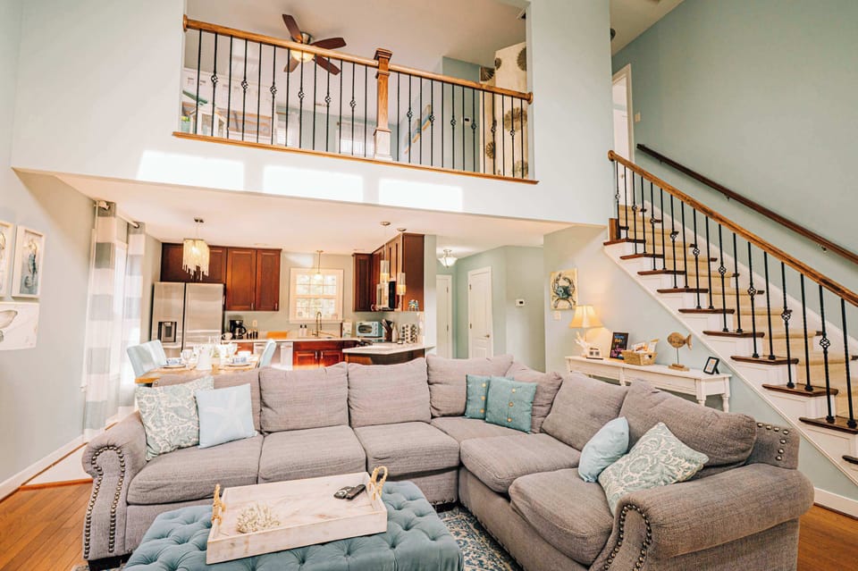 An open, airy living area with a sleeping loft overlooking the main space above. The loft adds extra flexibility while keeping the home bright, connected, and comfortably spacious for everyone to gather.