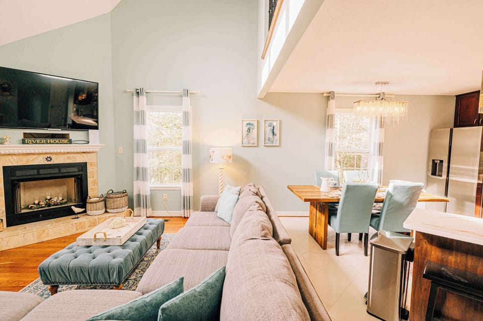 Open living room flows into the kitchen and dining area, with a table that seats six plus a bench from the sunporch for flexible gathering. An easy, connected space for meals, conversation, and downtime together.