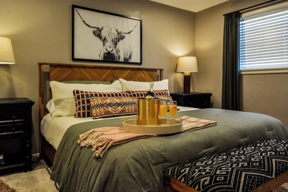 Sip, Relax & Celebrate Texas-Style 🥂 → A cozy king bed and a touch of luxury — your Abilene retreat awaits.