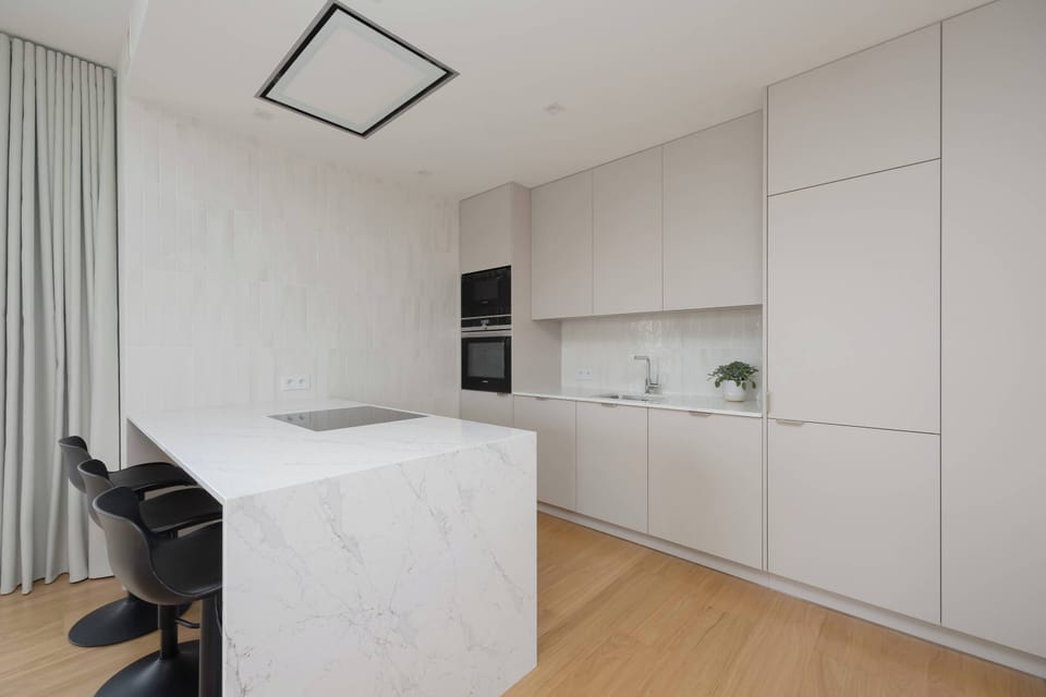 The minimalist white kitchen cabinetry impresses with its simplicity and elegance, offering functionality in a modern style.