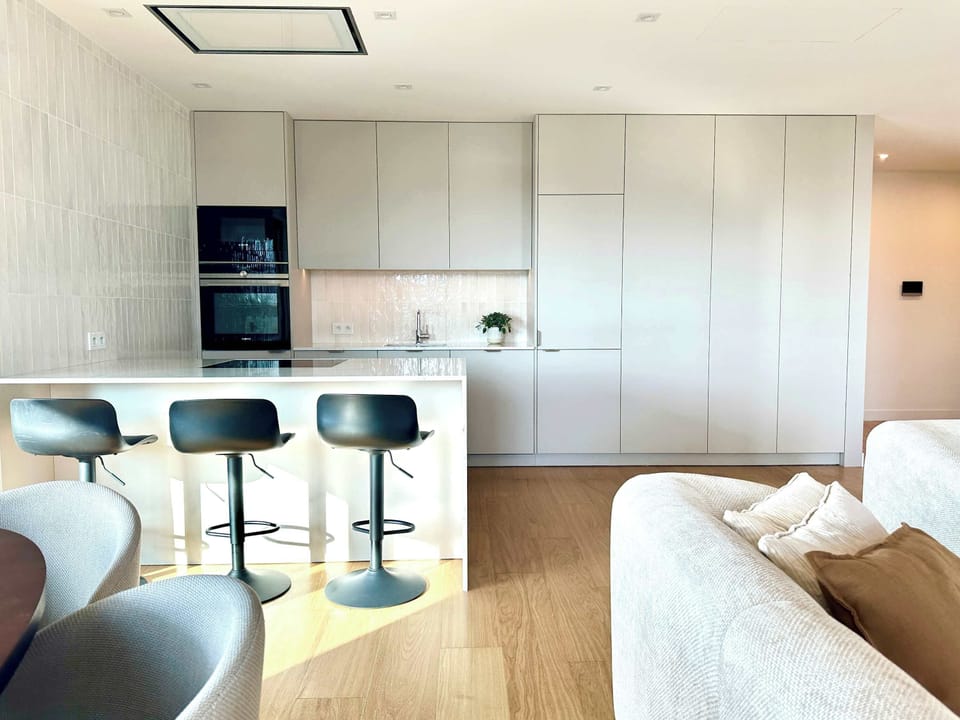 The kitchen island with high stools is the perfect spot for a quick breakfast or a chat over a cup of coffee.