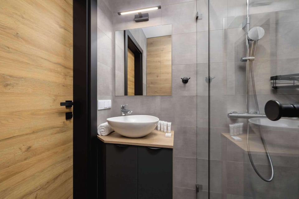 A well-appointed bathroom with a sink, a mirror, and a shower area, all with modern fixtures.