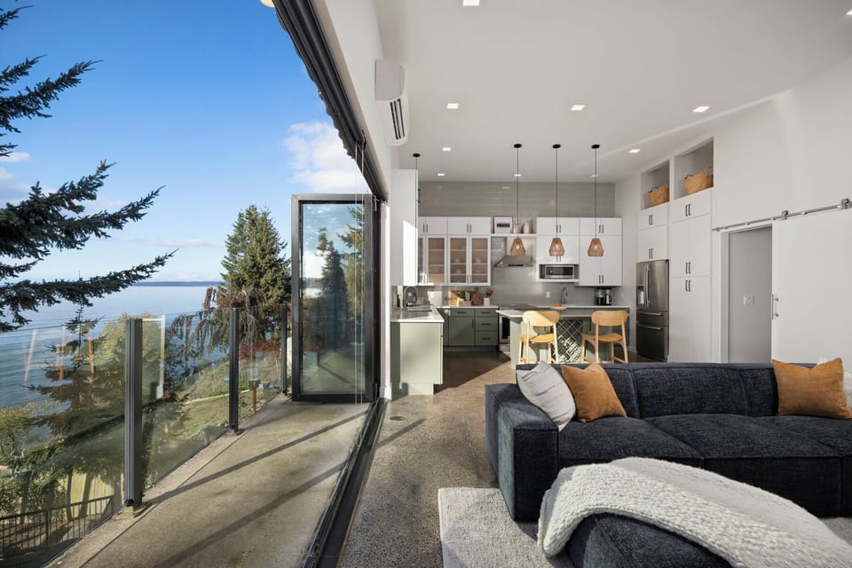 Open-concept design seamlessly connects living, dining, and kitchen spaces with stunning water views.