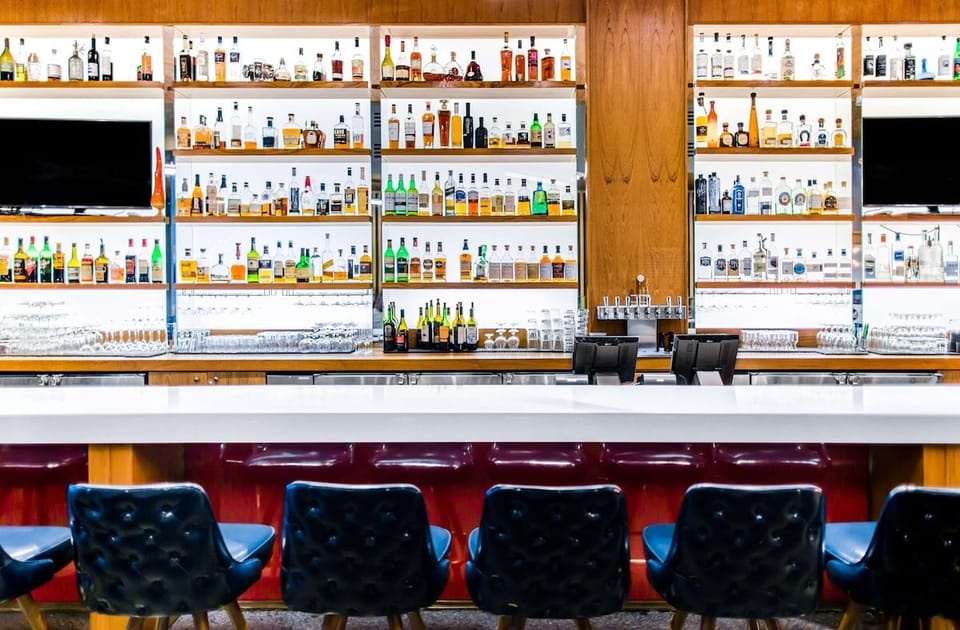 Sip craft cocktails at a sleek bar with glowing shelves.