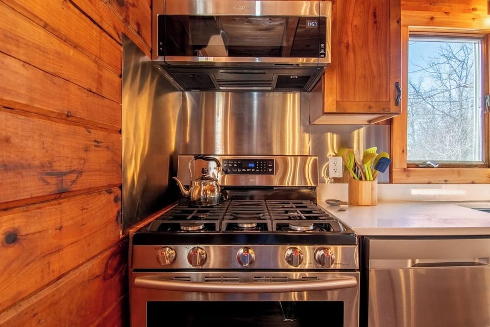 Convection stove, microwave and dishwasher. Exhaust fan vents outdoors.
