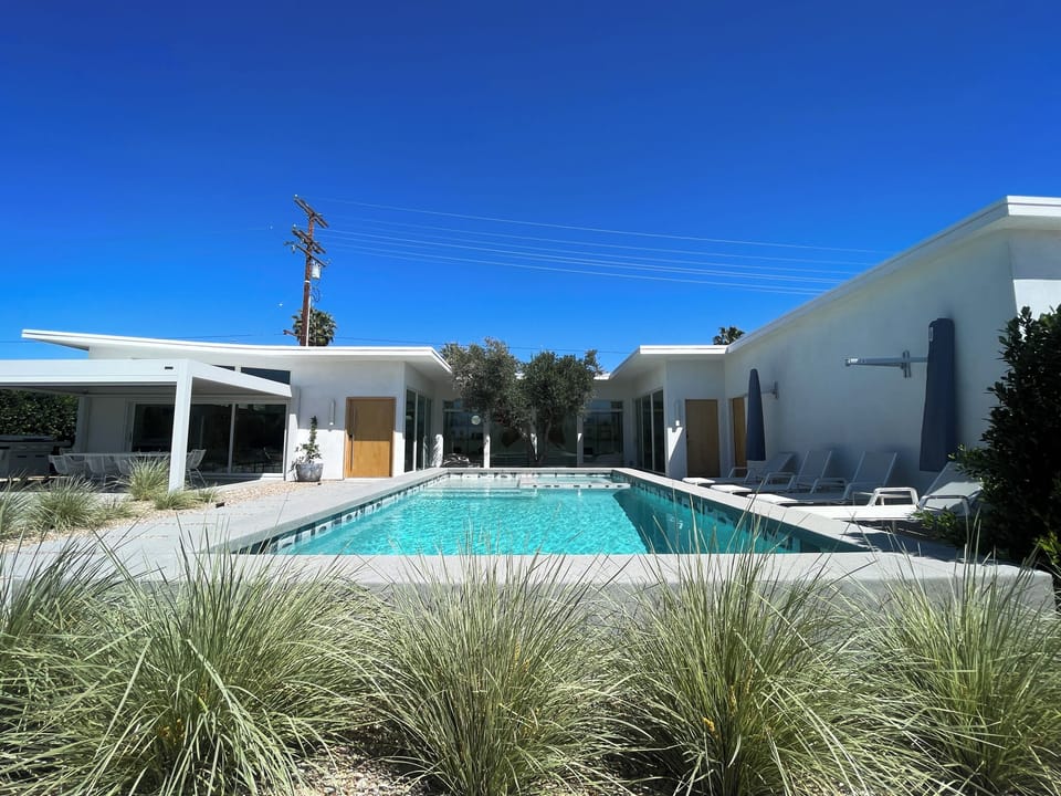 View of the front of the house with pool and spa.