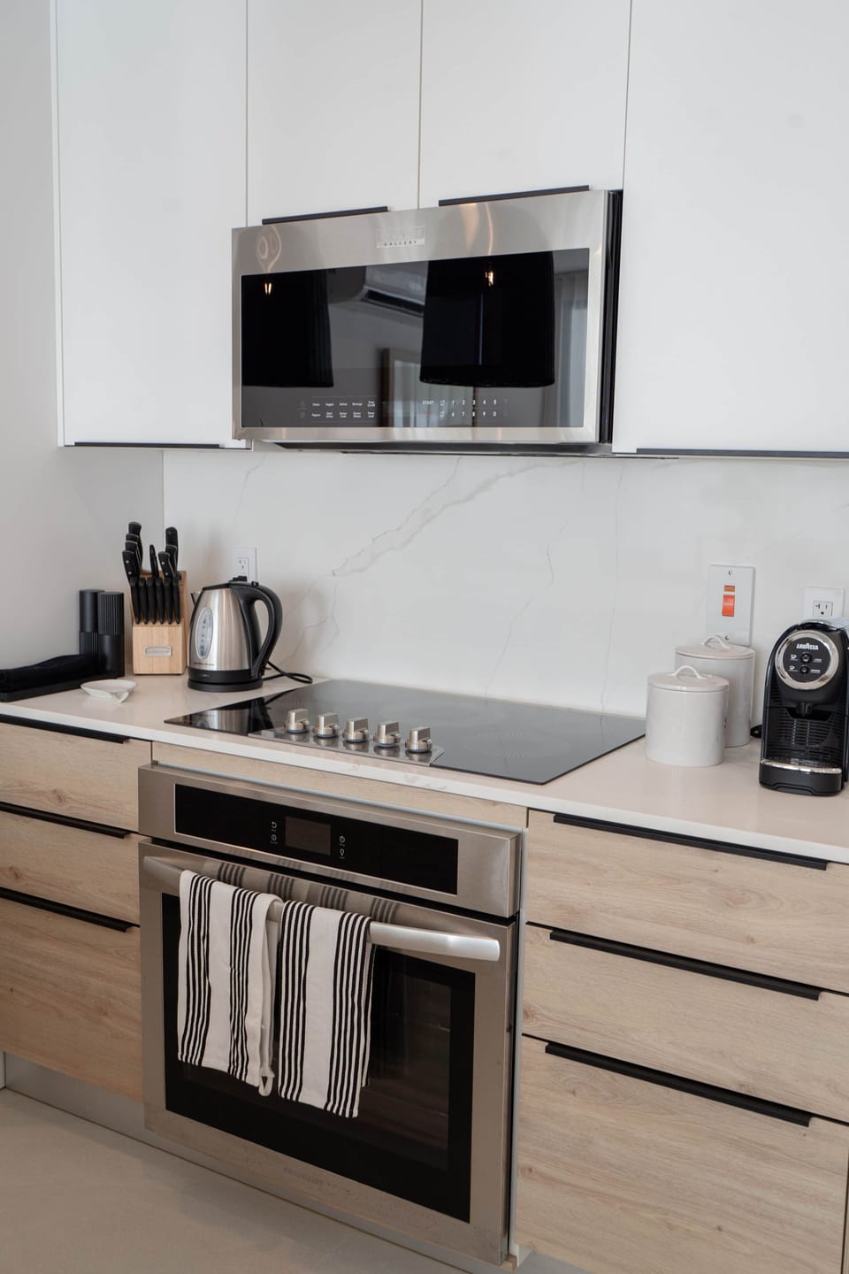 Fully equipped kitchen with stove, oven, microwave, Lavazza espresso maker, and electric kettle.