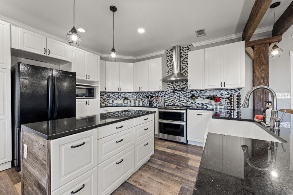 Kitchen with double ovens, microwave, dishwasher and more.
