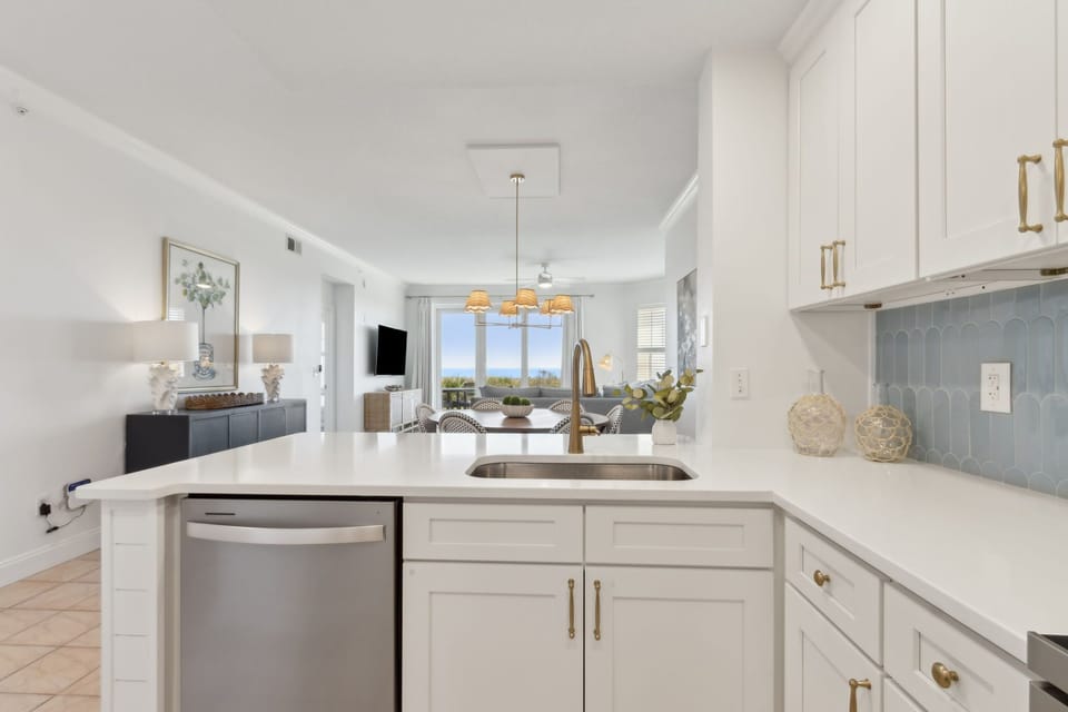 Luxury Completely Remodeled Kitchen with Stainless Steel Appliances, Stunning White Cabinetry, Quartz Countertops, a Shiplapped Island, and a Trendy Backsplash