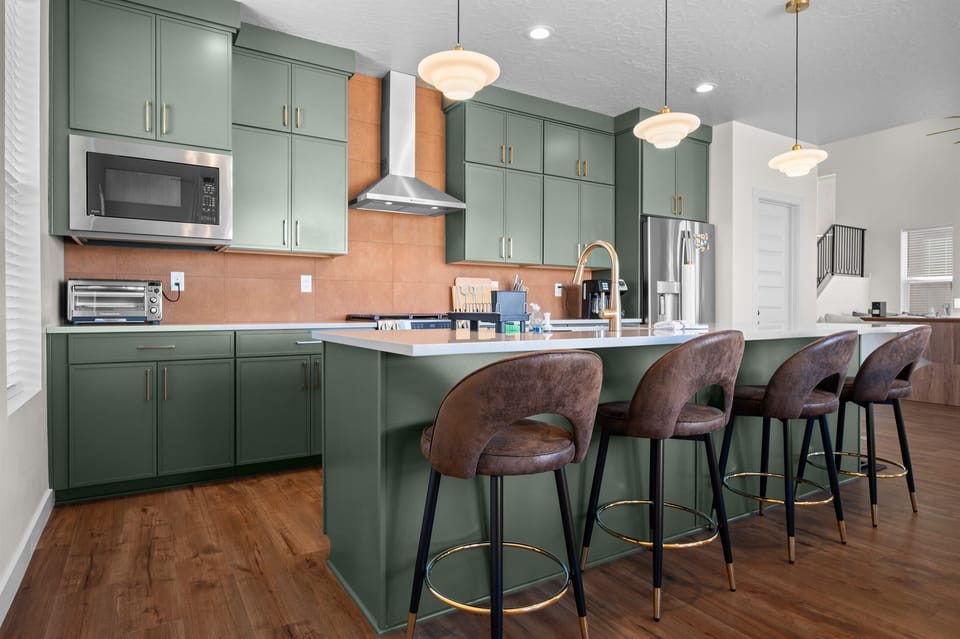 Gourmet kitchen setup with modern range hood, double oven, and full coffee station convenience.