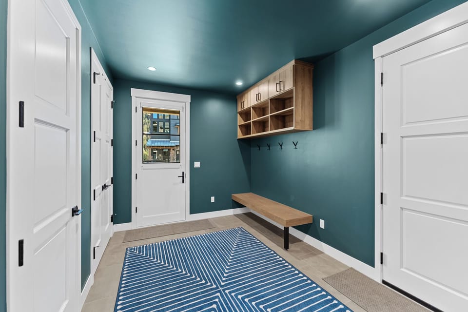 Drop your bags on the rich teal mudroom's bench and hang coats on the hooks—your stylish basecamp for adventures awaits.