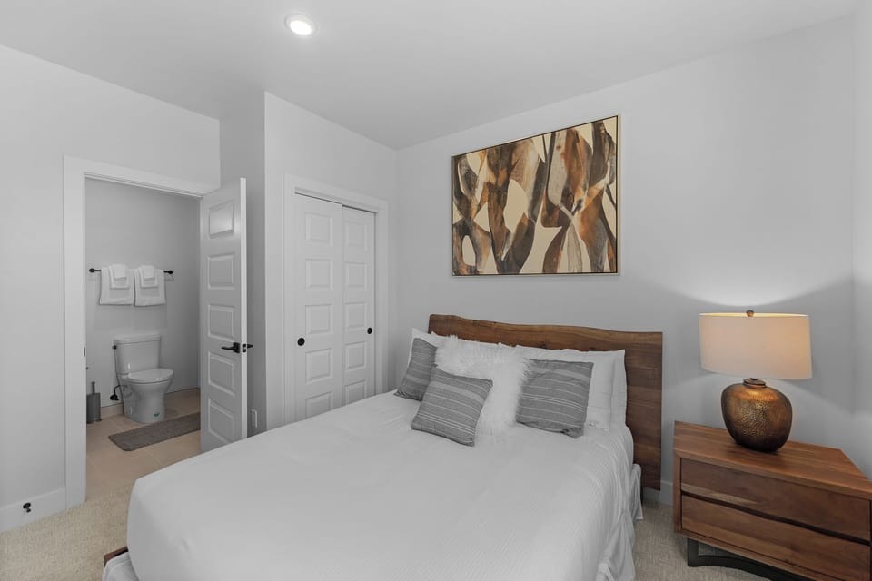 Unwind in your serene bedroom featuring crisp white linens, warm wood accents, and thoughtful art that creates the perfect retreat for restful nights.