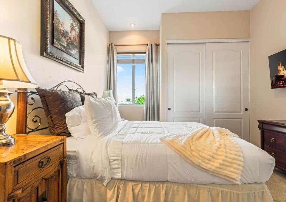 Enjoy a warm and inviting atmosphere with stylish décor, a classic wooden nightstand, and a mounted 