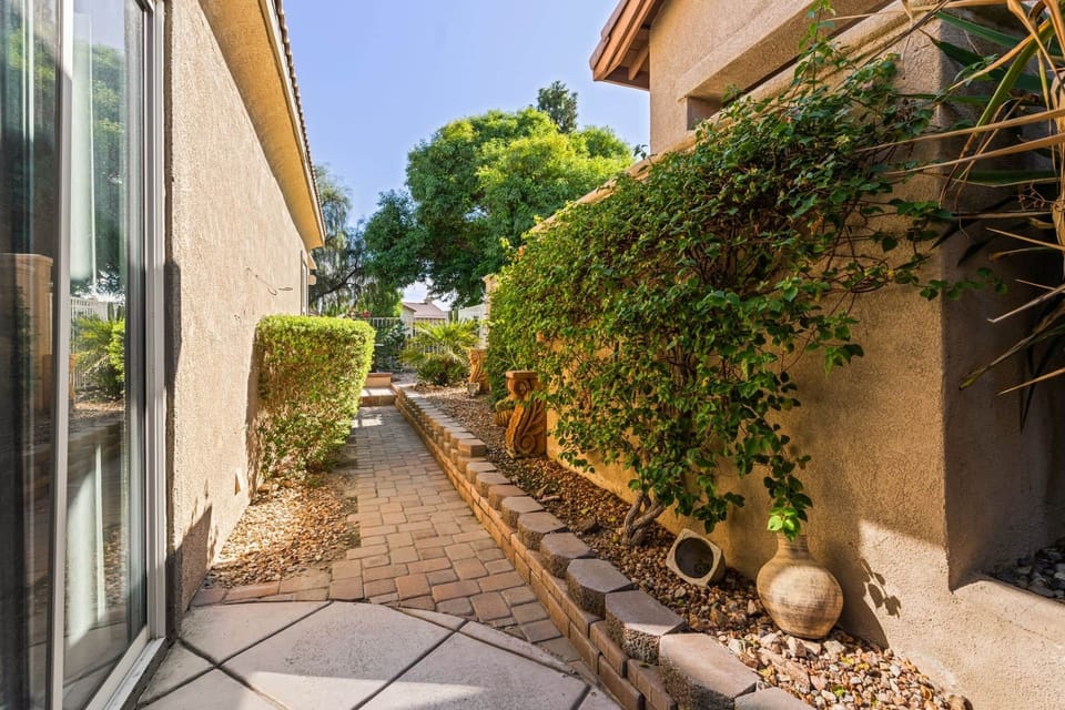 Step outside and enjoy a peaceful  walkway surrounded by lush greenery and charming decorative touch