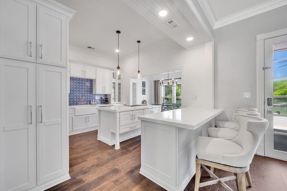 Kitchen has an island with stovetop as well as a peninsula with 3 swivel seats