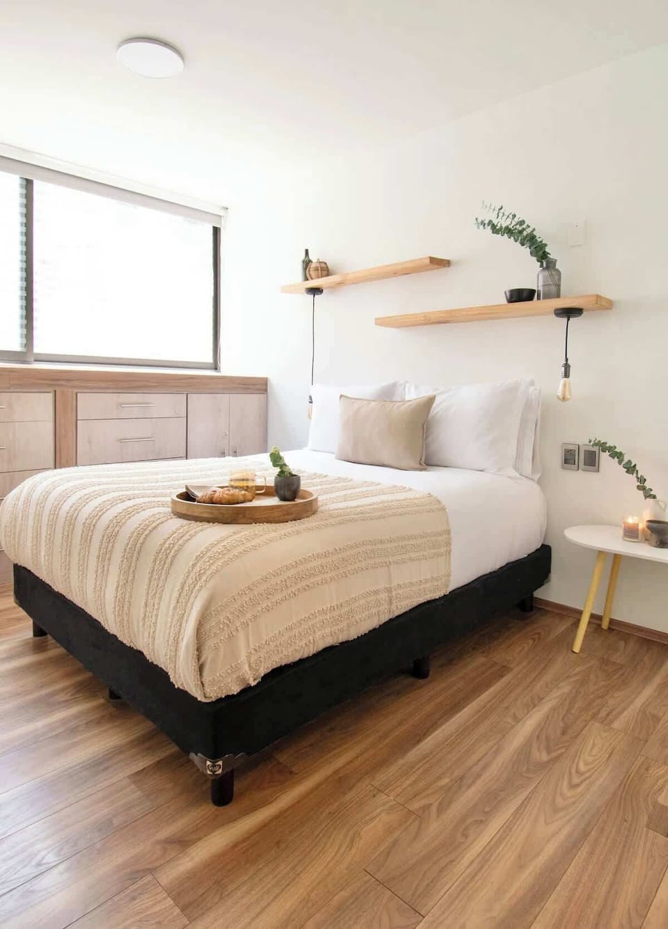 Cozy bedroom with natural light, soft bedding and warm decorative touches for a restful stay.