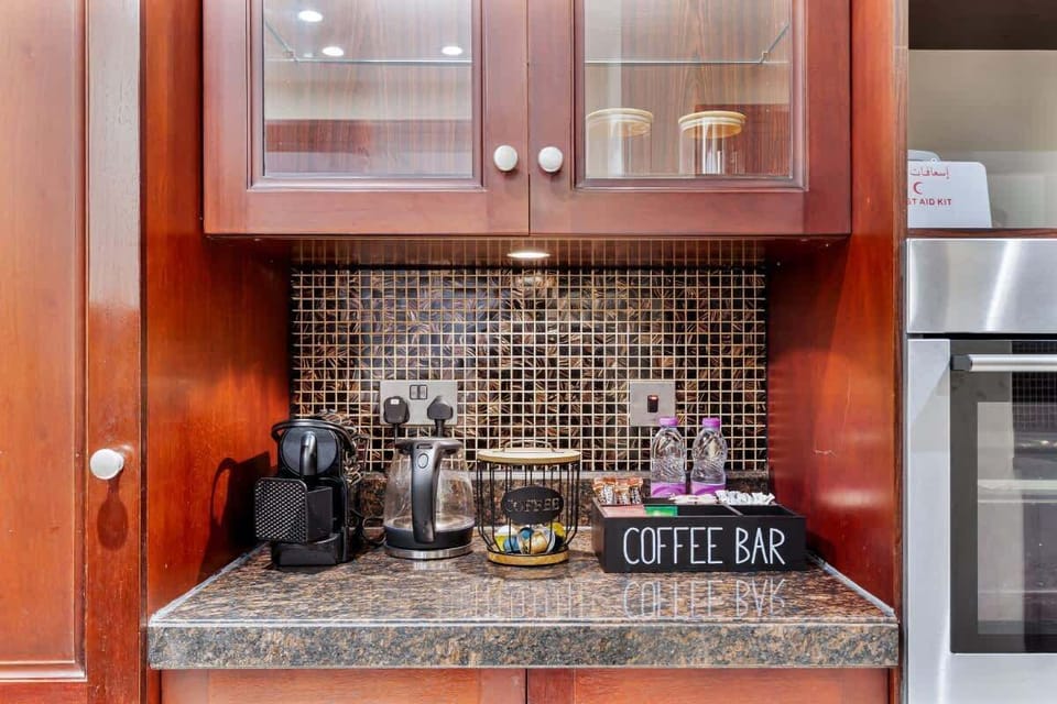 A fully equipped kitchen stocked with all essentials, including a coffee machine with pods, a selection of teas, sugar, and water for your convenience.